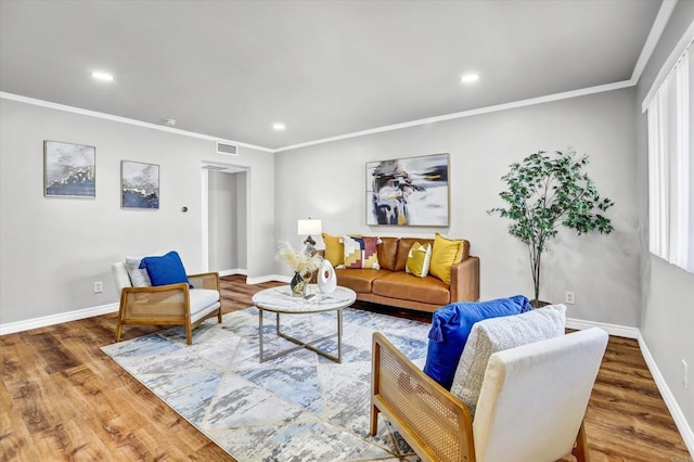 living area with visible vents, wood finished floors, baseboards, ornamental molding, and recessed lighting