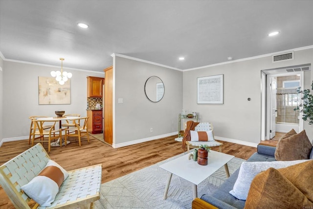 living area with crown molding, baseboards, and visible vents