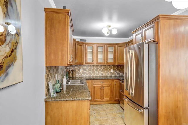 kitchen with a sink, decorative backsplash, stainless steel appliances, and brown cabinets