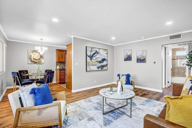 living room with a notable chandelier, visible vents, baseboards, and light wood-style floors