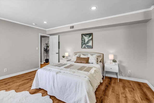 bedroom with recessed lighting, baseboards, wood finished floors, visible vents, and ornamental molding