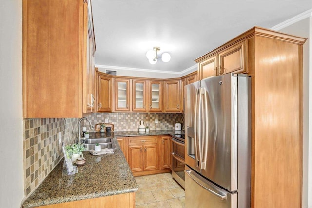 kitchen featuring brown cabinets, appliances with stainless steel finishes, ornamental molding, and a sink