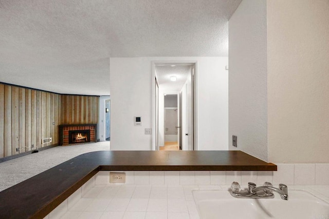 interior space featuring visible vents, a sink, a textured ceiling, and a fireplace