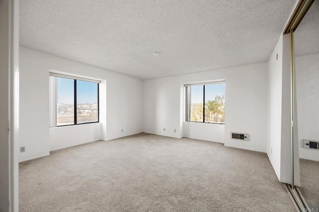 carpeted spare room featuring a textured ceiling