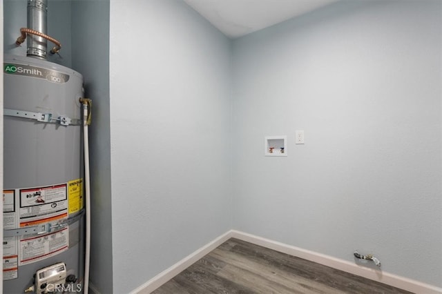 washroom with laundry area, strapped water heater, wood finished floors, baseboards, and hookup for a washing machine