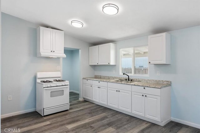 108 2nd St, Taft, CA 93268 - kitchen featuring white gas range oven, under cabinet range hood, dark wood-type flooring, and white cabinets