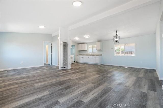 108 2nd St, Taft, CA 93268 - unfurnished living room with a chandelier, dark wood-style flooring, and a heating unit