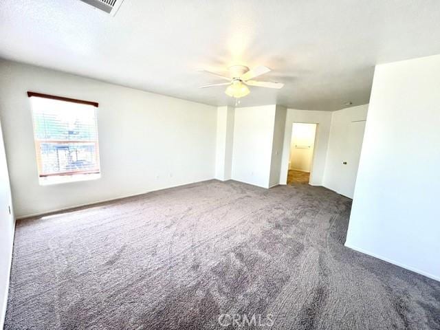 carpeted empty room with a ceiling fan and visible vents