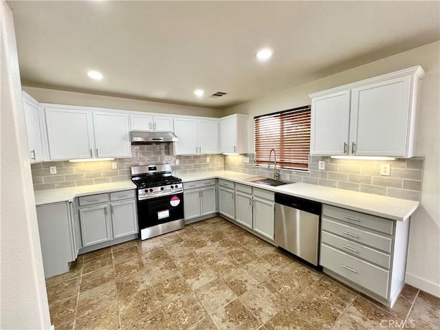 kitchen featuring a sink, under cabinet range hood, tasteful backsplash, and stainless steel appliances