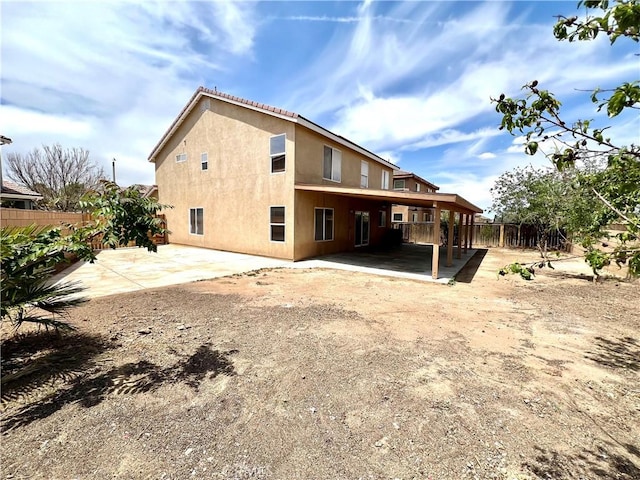 back of property with a patio, fence, and stucco siding