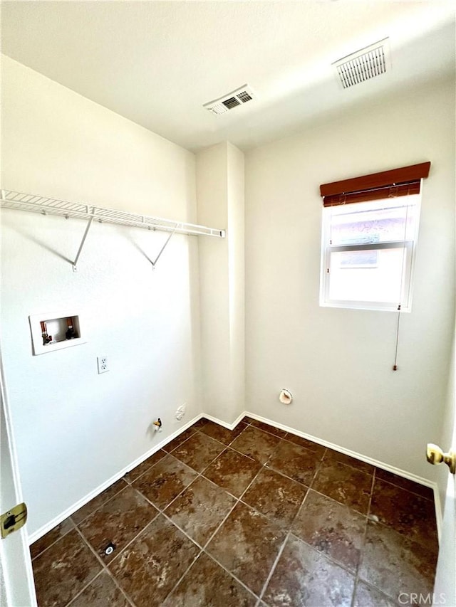 clothes washing area with laundry area, washer hookup, baseboards, hookup for a gas dryer, and visible vents