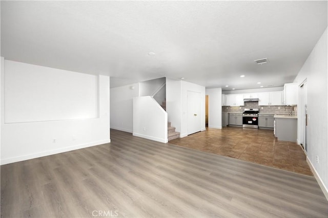 9331 Sapphire Ave, Hesperia, CA 92344 - unfurnished living room featuring recessed lighting, baseboards, stairs, and wood finished floors
