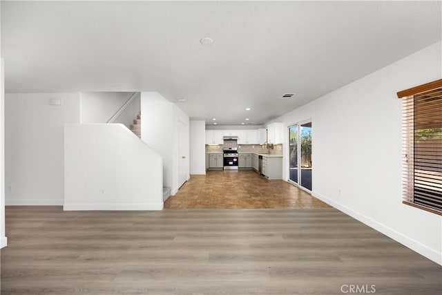 9331 Sapphire Ave, Hesperia, CA 92344 - unfurnished living room featuring recessed lighting, baseboards, stairs, and light wood-type flooring