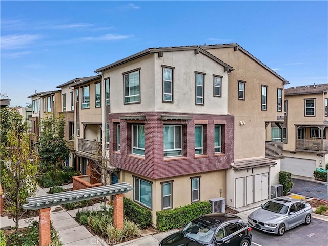 view of property with central AC and uncovered parking