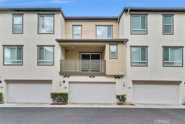 view of property featuring an attached garage and stucco siding