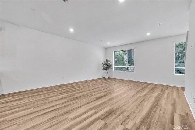 unfurnished room featuring recessed lighting, baseboards, and light wood-type flooring