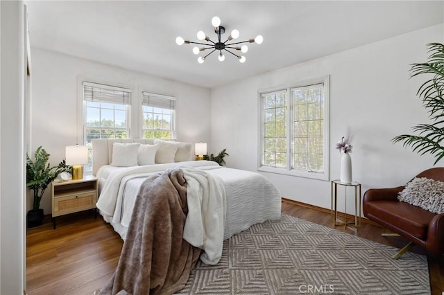 10703 Wheatland Ave, Sunland, CA 91040 - bedroom featuring multiple windows, dark wood-style flooring, and a notable chandelier