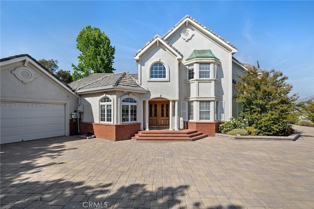 10703 Wheatland Ave, Sunland, CA 91040 - view of front of house with brick siding, decorative driveway, stucco siding, and french doors