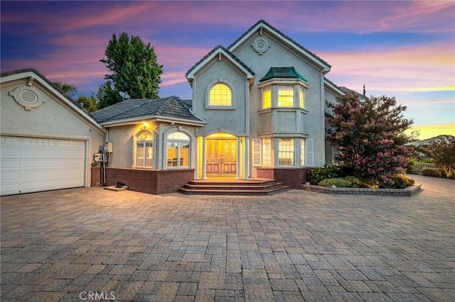 10703 Wheatland Ave, Sunland, CA 91040 - view of front of home with brick siding, decorative driveway, a garage, and stucco siding
