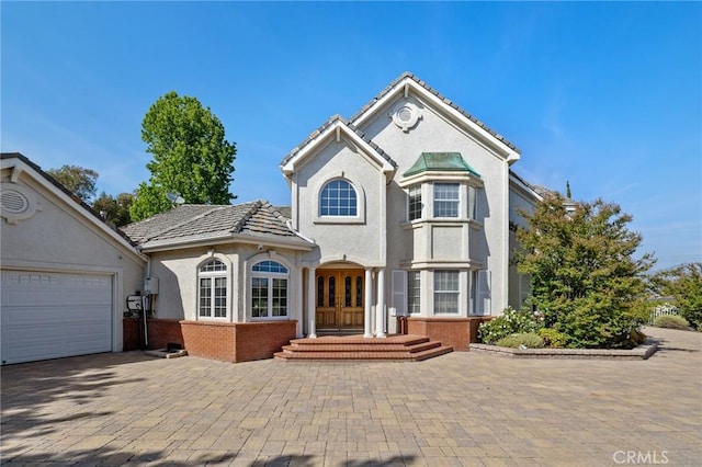 10703 Wheatland Ave, Sunland, CA 91040 - view of front of house featuring brick siding, decorative driveway, stucco siding, and french doors