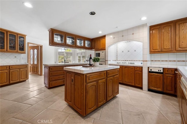 10703 Wheatland Ave, Sunland, CA 91040 - kitchen with brown cabinetry, backsplash, recessed lighting, white appliances, and stone tile floors