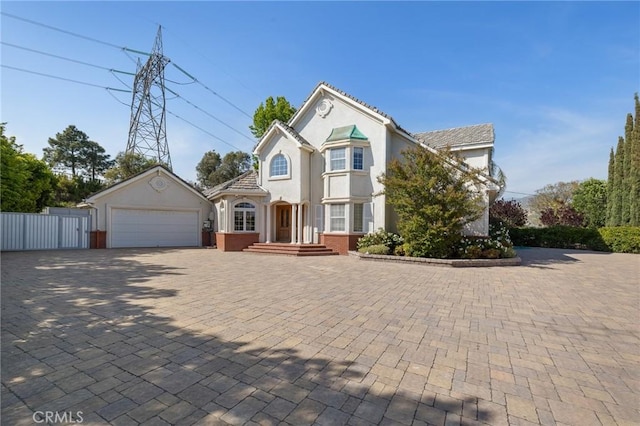 10703 Wheatland Ave, Sunland, CA 91040 - traditional-style house with fence, an attached garage, brick siding, stucco siding, and driveway