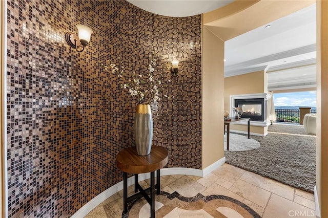 bathroom with baseboards, stone tile flooring, and a multi sided fireplace