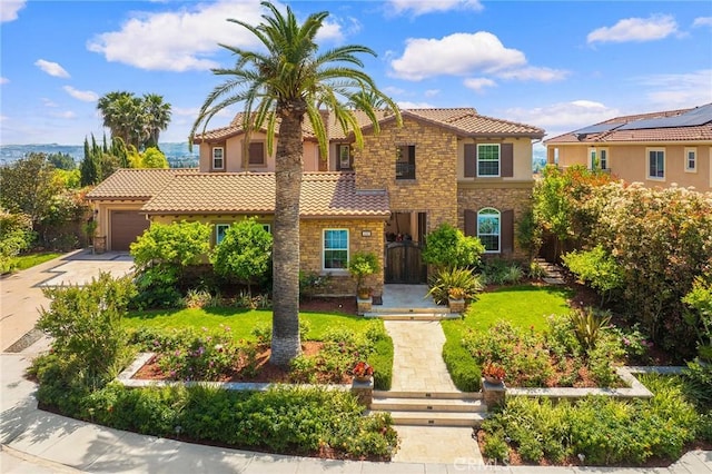 mediterranean / spanish home with an attached garage, a tile roof, stone siding, stucco siding, and concrete driveway