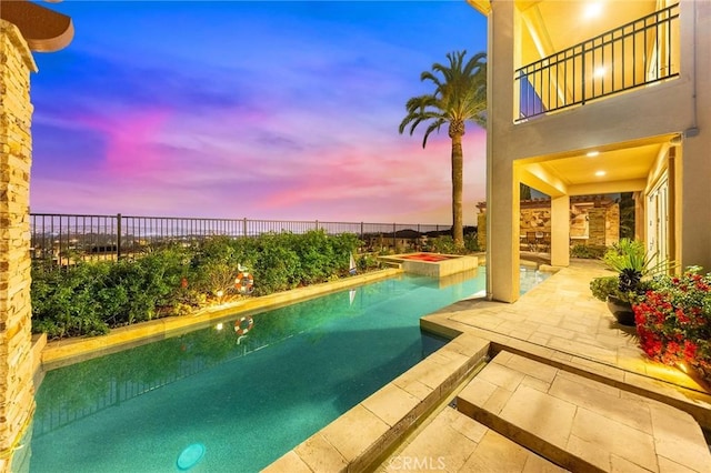 pool at dusk featuring a fenced in pool, a fenced backyard, and a patio area