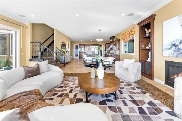 living area featuring recessed lighting, baseboards, a glass covered fireplace, and stairs