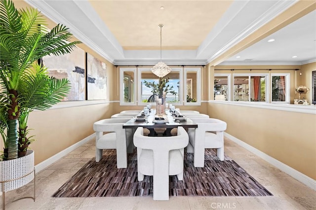 dining room with baseboards, ornamental molding, a raised ceiling, and a notable chandelier