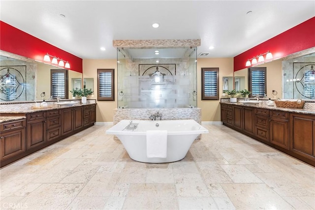 full bath featuring a sink, a stall shower, and stone tile floors