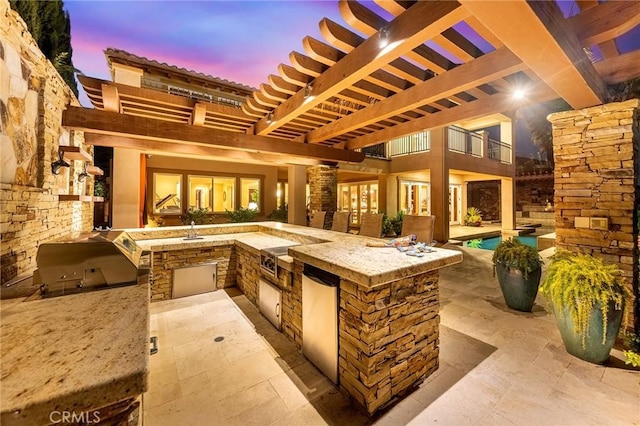 view of patio featuring a sink, a grill, area for grilling, and an outdoor pool
