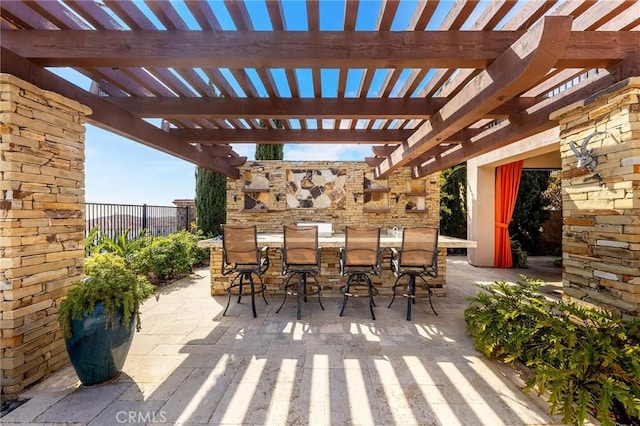 view of patio / terrace with a pergola, fence, and outdoor dry bar