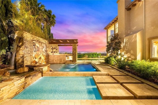 pool at dusk featuring a patio and an outdoor pool