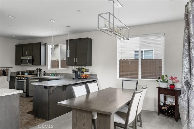 4575 Castillo Dr, Guadalupe, CA 93434 - kitchen featuring appliances with stainless steel finishes, a sink, decorative light fixtures, a peninsula, and a breakfast bar area