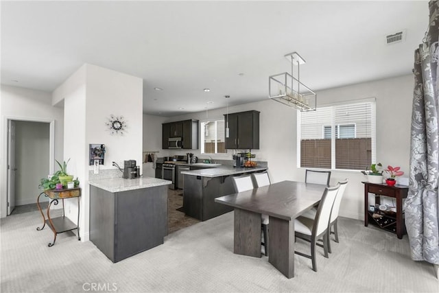 4575 Castillo Dr, Guadalupe, CA 93434 - kitchen with light carpet, light countertops, a peninsula, appliances with stainless steel finishes, and baseboards