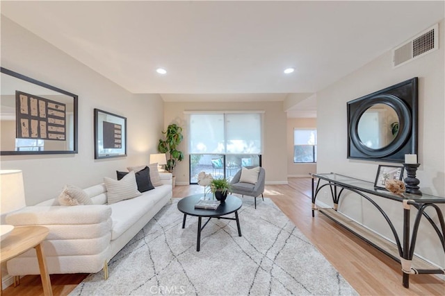 living room featuring recessed lighting, baseboards, light wood finished floors, and visible vents
