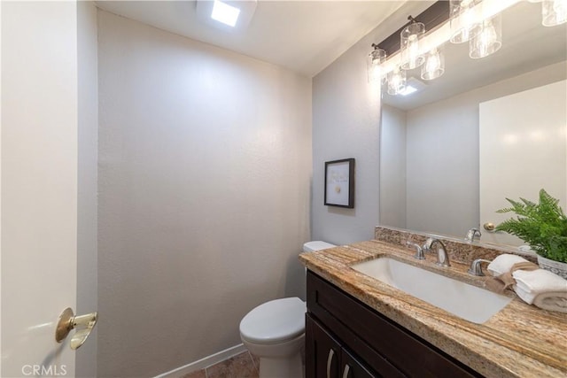 half bathroom featuring vanity, baseboards, and toilet