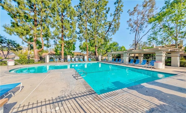 pool featuring fence and a patio area