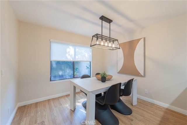 dining area with baseboards and wood finished floors