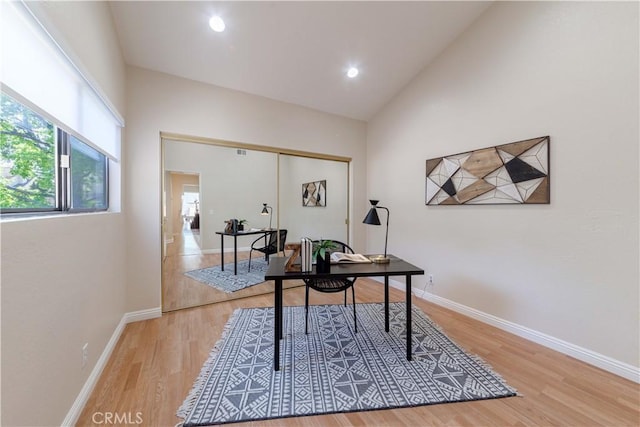 office space with recessed lighting, baseboards, high vaulted ceiling, and light wood-style floors