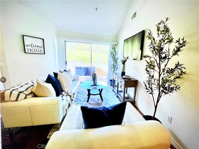 living area featuring baseboards, visible vents, and high vaulted ceiling