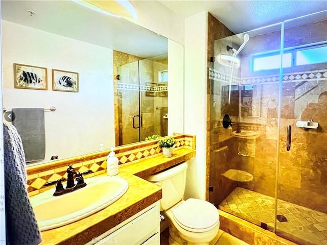 full bath with vanity, a stall shower, and toilet
