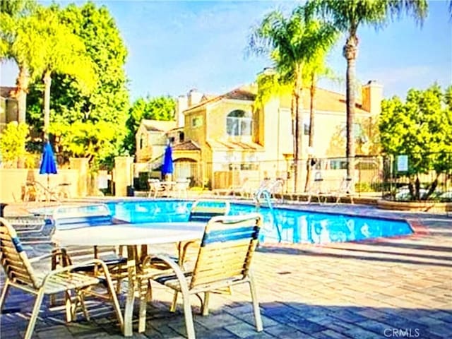 pool featuring fence and a patio area