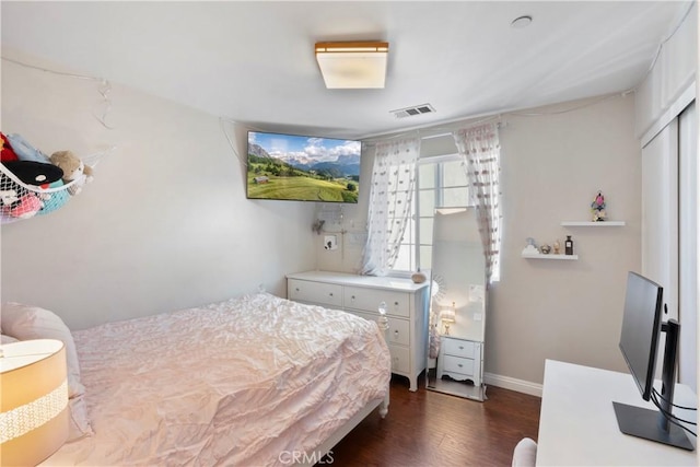 bedroom with baseboards, visible vents, and dark wood-type flooring