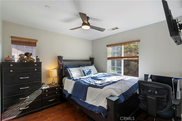 bedroom with a ceiling fan, dark wood-style floors, and visible vents