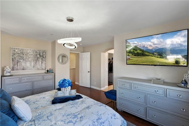 6239 Longmeadow St, Riverside, CA 92505 - bedroom featuring arched walkways, a chandelier, a walk in closet, baseboards, and dark wood-style floors