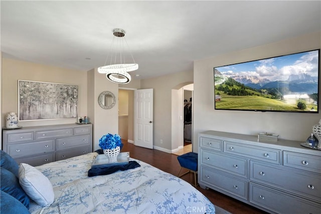 6239 Longmeadow St, Riverside, CA 92505 - bedroom featuring arched walkways, dark wood-style flooring, a chandelier, and a walk in closet