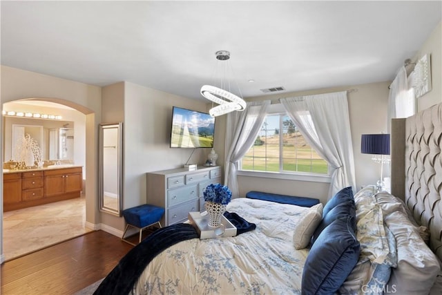 6239 Longmeadow St, Riverside, CA 92505 - bedroom with light wood-style floors, arched walkways, ensuite bath, and baseboards